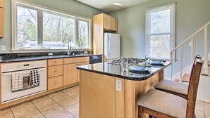 Una cocina moderna con una isla central, armarios de madera y lavavajillas integrado.