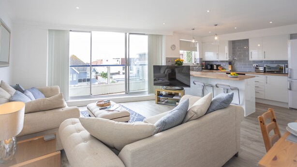 Een modern appartement met woonkamer, keuken en balkon.