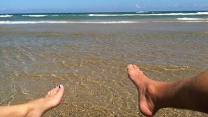 A beach scene with clear water and a visible sandy shore. - Sea Forever - Front Row, Fire Pit & Miles of Surf! (Surfside Beach)