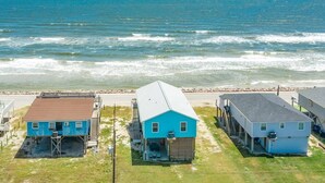 A coastal property with three buildings, a sandy beach, and the ocean. - Sea Forever - Front Row, Fire Pit & Miles of Surf! (Surfside Beach)