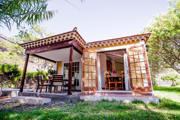 Una pequeña estructura al aire libre con techo de tejas y un patio cubierto.