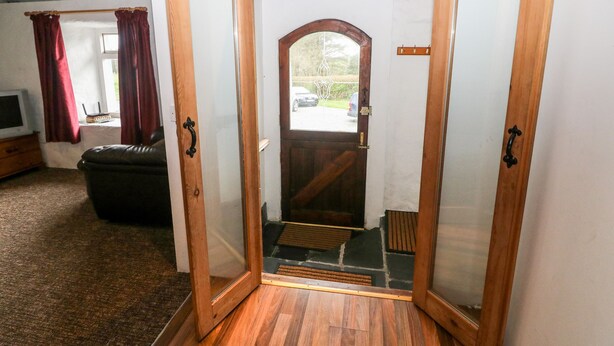 Puerta de madera con panel de vidrio que da a una escalera de piedra.