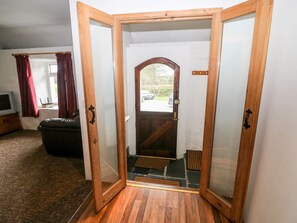 A wooden-framed door with a glass panel, leading to a stone staircase.