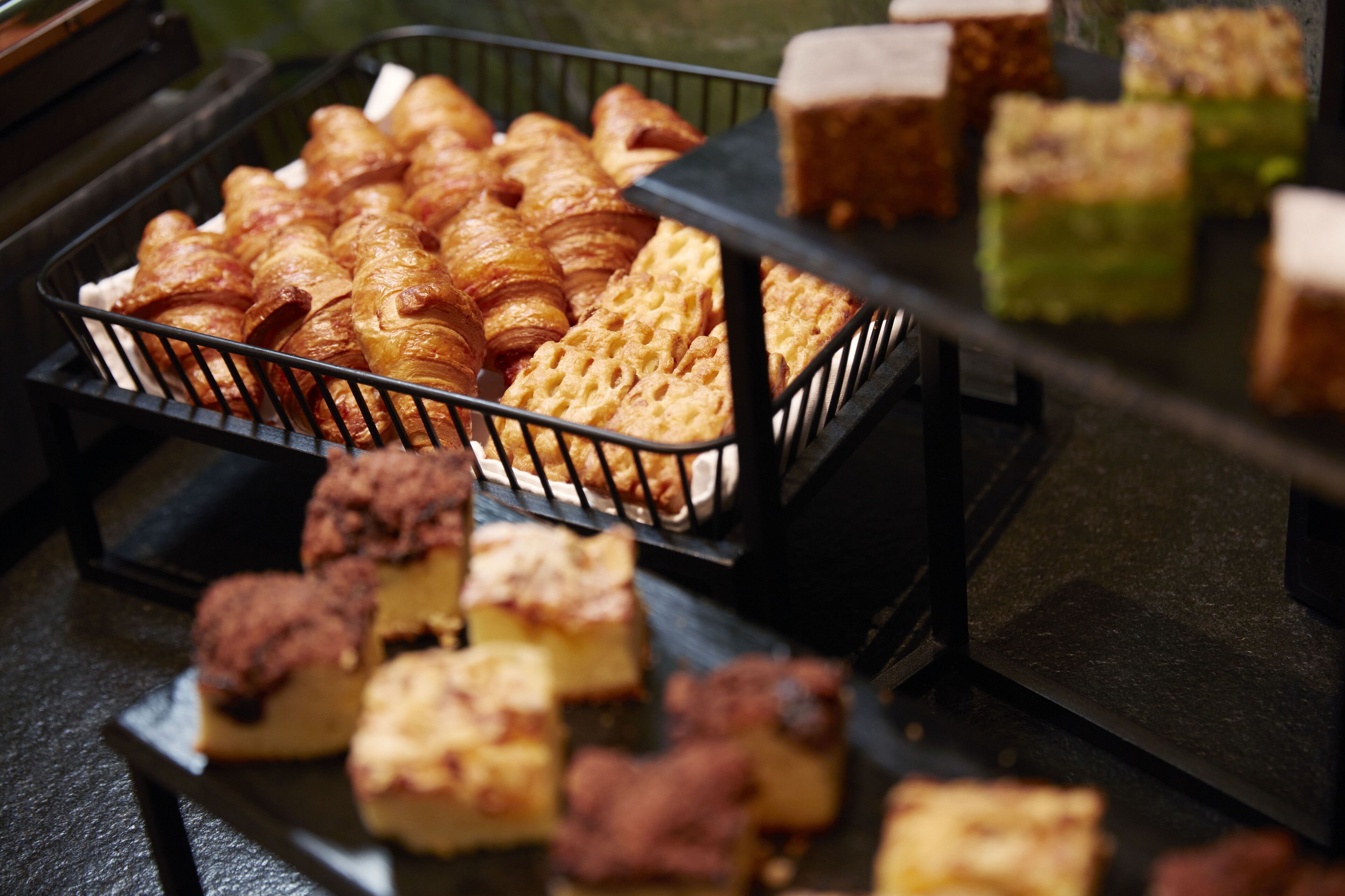 A variety of baked goods in a display case, including croissants and other pastries.