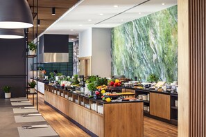 A modern breakfast bar with wooden counters and a marble wall backdrop. - Q Hotel Plus Wrocław Bielany (Kobierzyce)