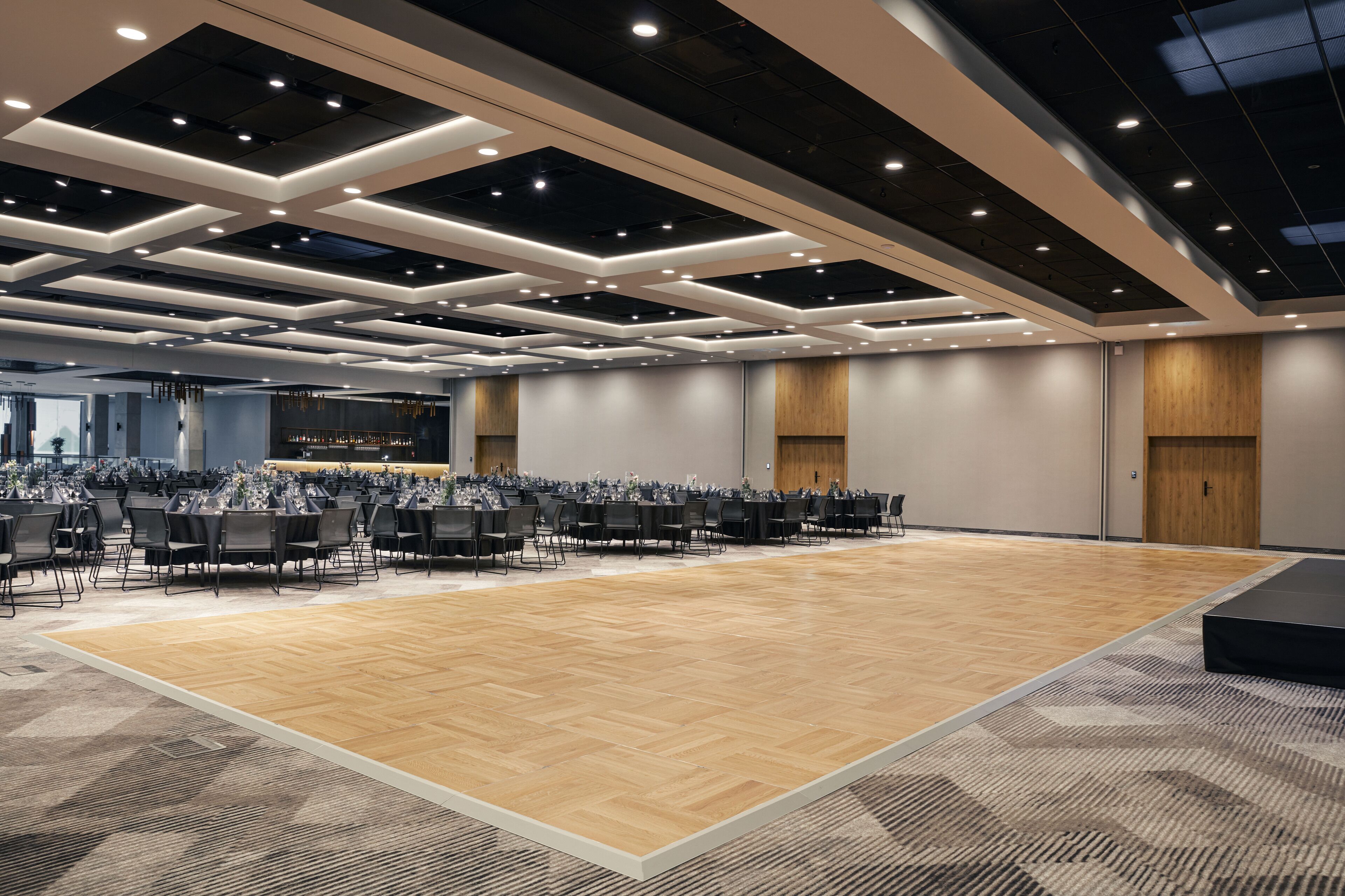 A spacious conference room with a high ceiling, modern lighting, and a large seating area.