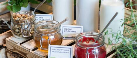 A wooden crate with jars of food items, including honey and jam, and labeled signs.