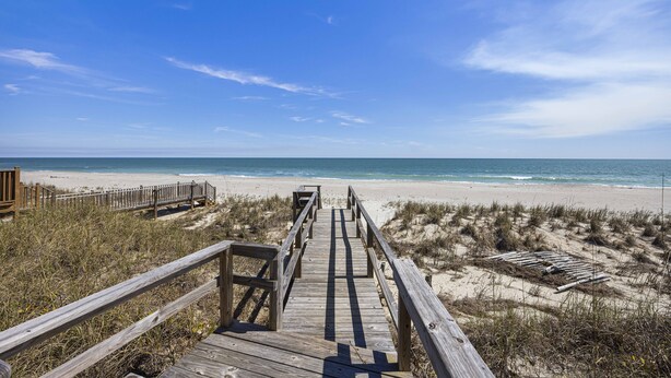 A wooden boardwalk leading to a beach with dunes and a clear sky. - Fincastle - 5 bedroom, Oceanfront (Pawleys Island)