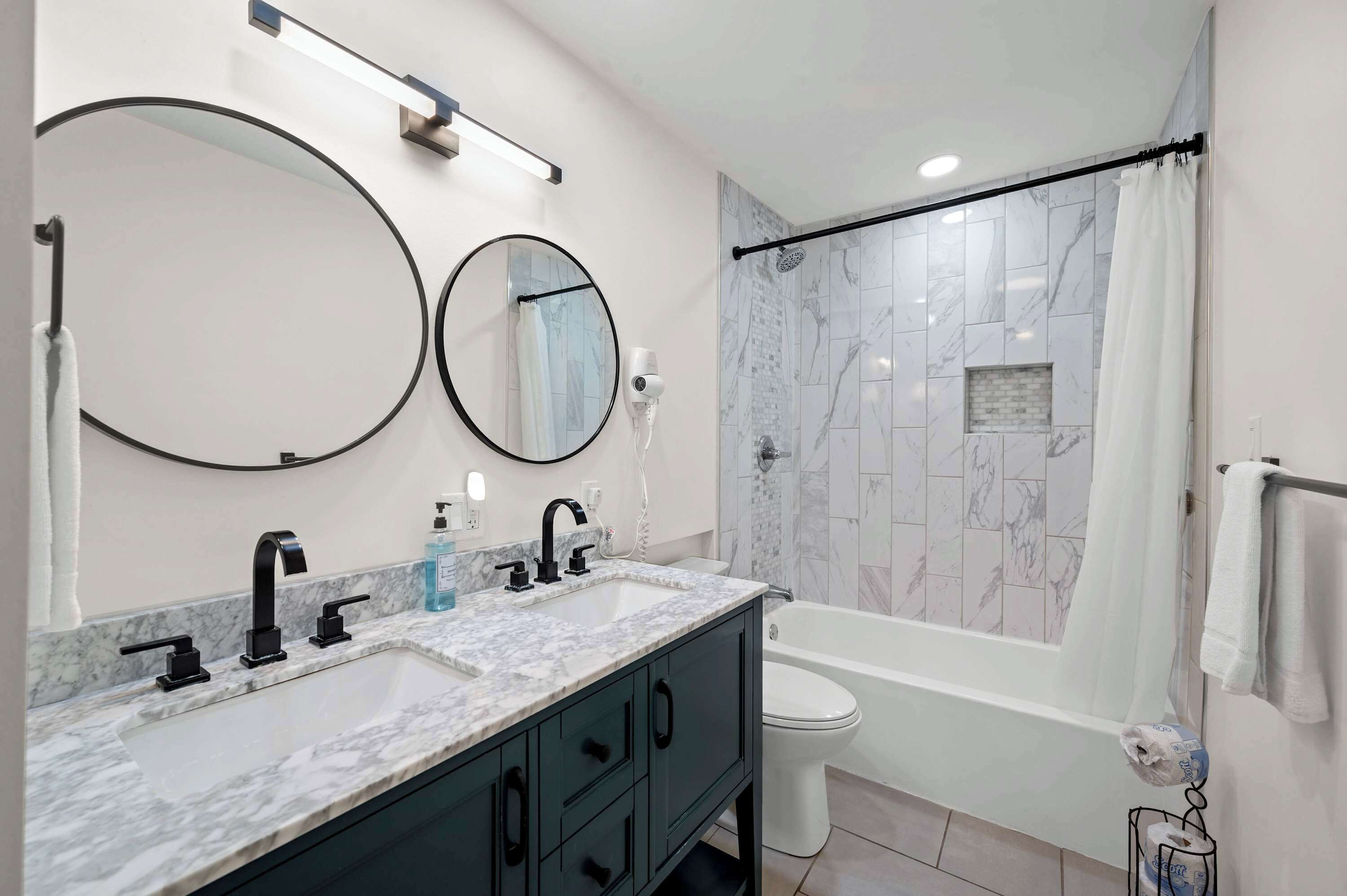 Bathtub, hair dryer, towels, shampoo