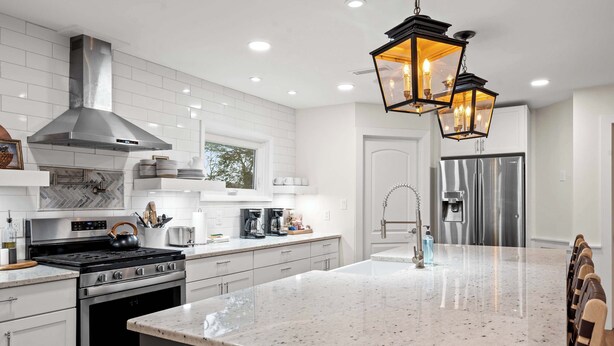A modern kitchen with white cabinetry, stainless steel appliances, and a large marble island. - Spacious Home for 12 Near Ark - w/Pool & Hot Tub! (Williamstown)
