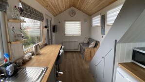 A compact kitchen with wooden countertops, a built-in sink, and a microwave. - Ashmere Tiny House . Adults Only (Coldingham, Eyemouth)