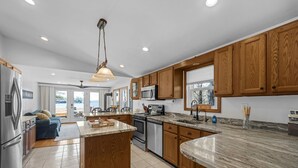 A modern kitchen with wooden cabinets, granite countertops, and stainless steel appliances.