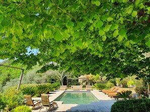 A pool area with lounge chairs and a pergola.