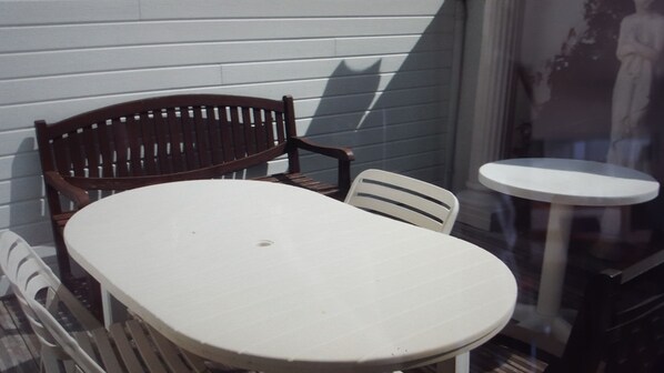 A dining area with a wooden chair and a small round table. - Charming little apartment near port, beaches and village (Larmor-Baden)
