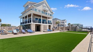 A large, two-story house with a spacious backyard, a swimming pool, and a well-maintained lawn. - Luxury Home with Private Pool and Stunning Views (Garden City Beach)