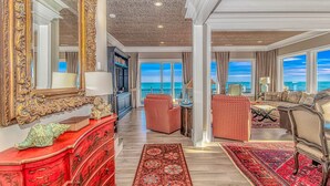 A spacious living room with a large mirror, red furniture, and a view of the ocean. - Luxury Home with Private Pool and Stunning Views (Garden City Beach)