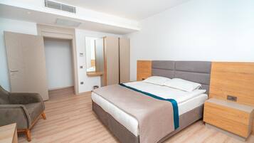 A modern bedroom with a bed, bedside table, and a chair.
