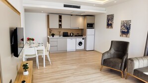 A modern apartment with a dining area, kitchen, and living space.