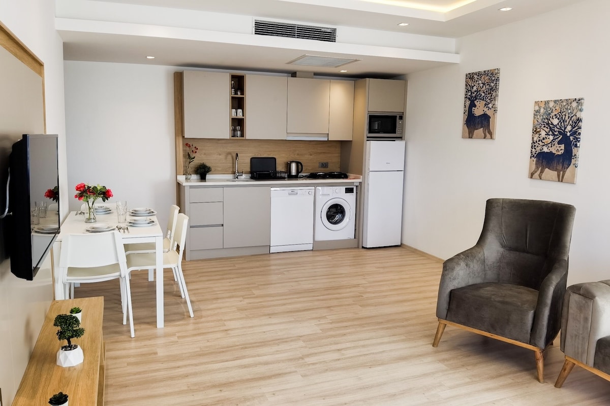 A modern apartment with a dining area, kitchen, and living space.