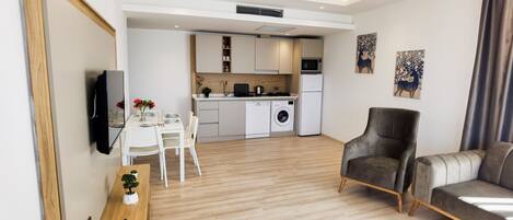 A modern apartment with a dining area, kitchen, and living space.