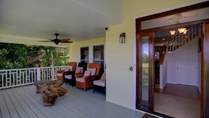 A wooden deck with outdoor seating, a ceiling fan, and a staircase leading to an interior room. - Hawaiian Dream with Pool (Pepeekeo)