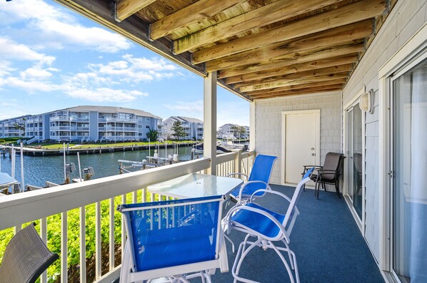 Un balcon donnant sur une marina, avec des bâtiments en arrière-plan.