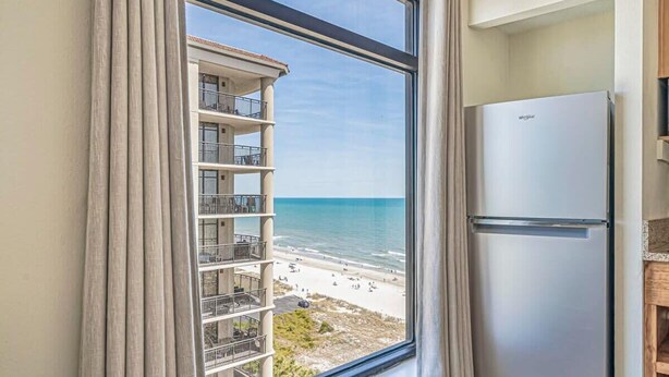 Une cuisine avec vue sur la plage et un balcon doté de balustrades.