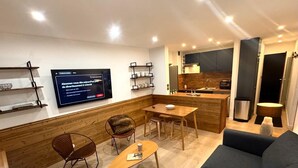 Una sala de estar moderna con un sofá, una mesa de centro y un televisor montado en la pared.