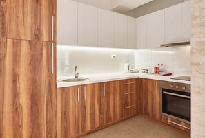 Enjoy cooking in this well-equipped kitchen with a stainless steel sink, kettle, and stove.