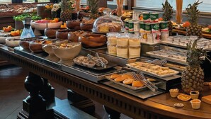 A buffet with various food items, a chandelier, and a framed picture on the wall. - Meroddi Barnathan Hotel (Istanbul)