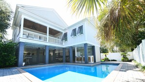 Une maison à deux étages avec une piscine, un balcon et un patio.