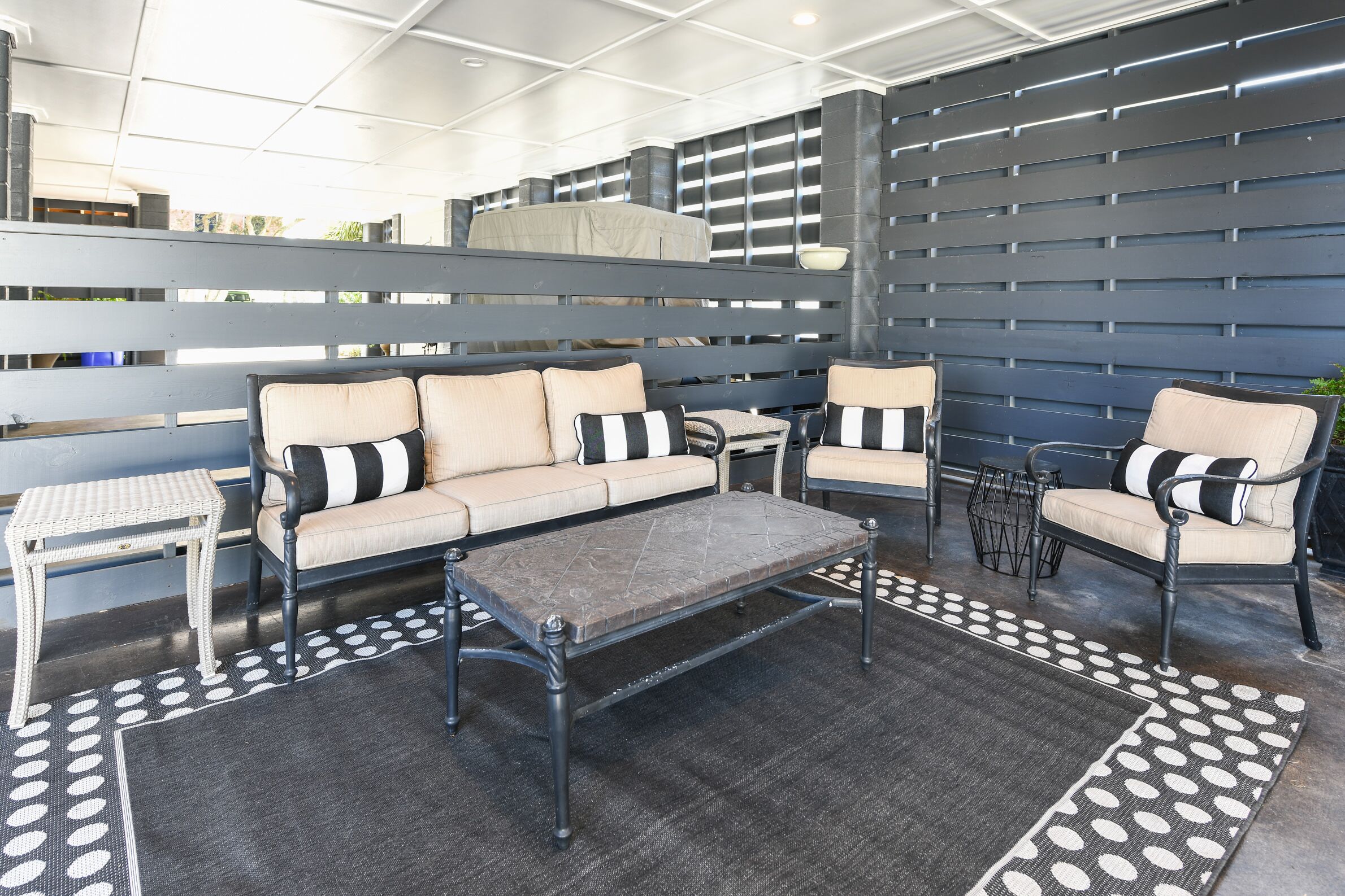A modern outdoor seating area with a sofa, chairs, and a coffee table.