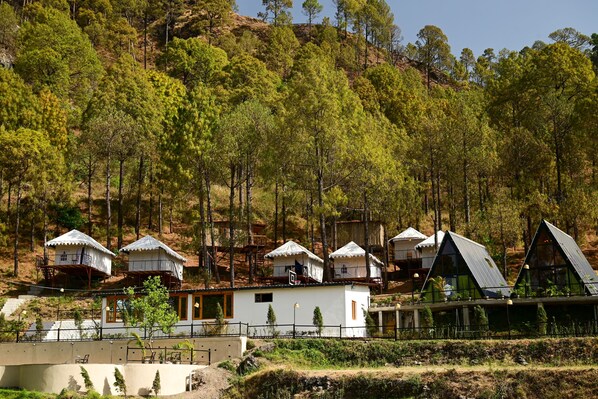A row of A-frame cabins with a view of a forested hillside. - Paradise Pool Resort (Nainital)