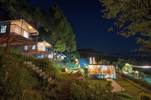 A two-story house with a balcony, surrounded by trees and a clear night sky. - Paradise Pool Resort (Nainital)