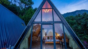 A triangular glass-roofed structure with a bed, a hanging chair, and a dining area visible through the glass. - Paradise Pool Resort (Nainital)