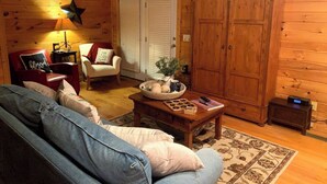 A cozy wooden cabin interior with a sofa, a chair, a coffee table with a basket, and a cabinet. - ⭐️Glory Days Cottage⭐️ Cozy/Quiet/Serene🏡 (Mentone)
