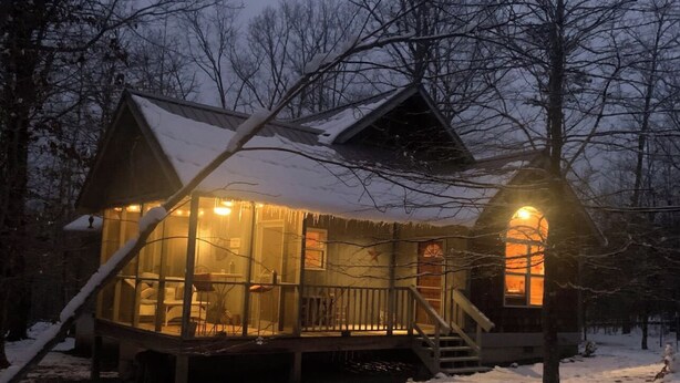 A cabin with a glass enclosure, wooden deck, and a lit exterior light. - ⭐️Glory Days Cottage⭐️ Cozy/Quiet/Serene🏡 (Mentone)