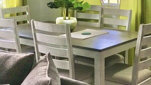 A dining area with a table, chairs, and a plant.