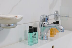Habitación triple, balcón | Baño | Secador de pelo y toallas