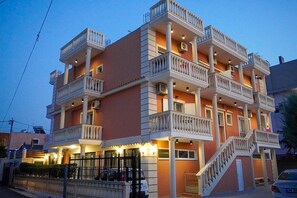 A multi-story building with balconies, a staircase, and a gated entrance. - Hotel Marku (Sarandë)