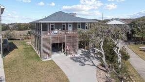 A two-story house with a covered porch and a small deck. - Canalfront Dog Friendly Home in Frisco with Elevator and Private Boat Dock (Frisco)