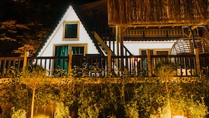 Uma casa com telhado triangular, estrutura de colmo e cúpula esférica.