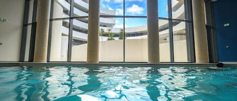 Una piscina cubierta, una piscina al aire libre de temporada, tumbonas