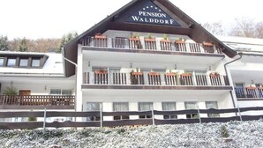 Un edificio de varios pisos con un letrero que dice "Pension Walddorf".