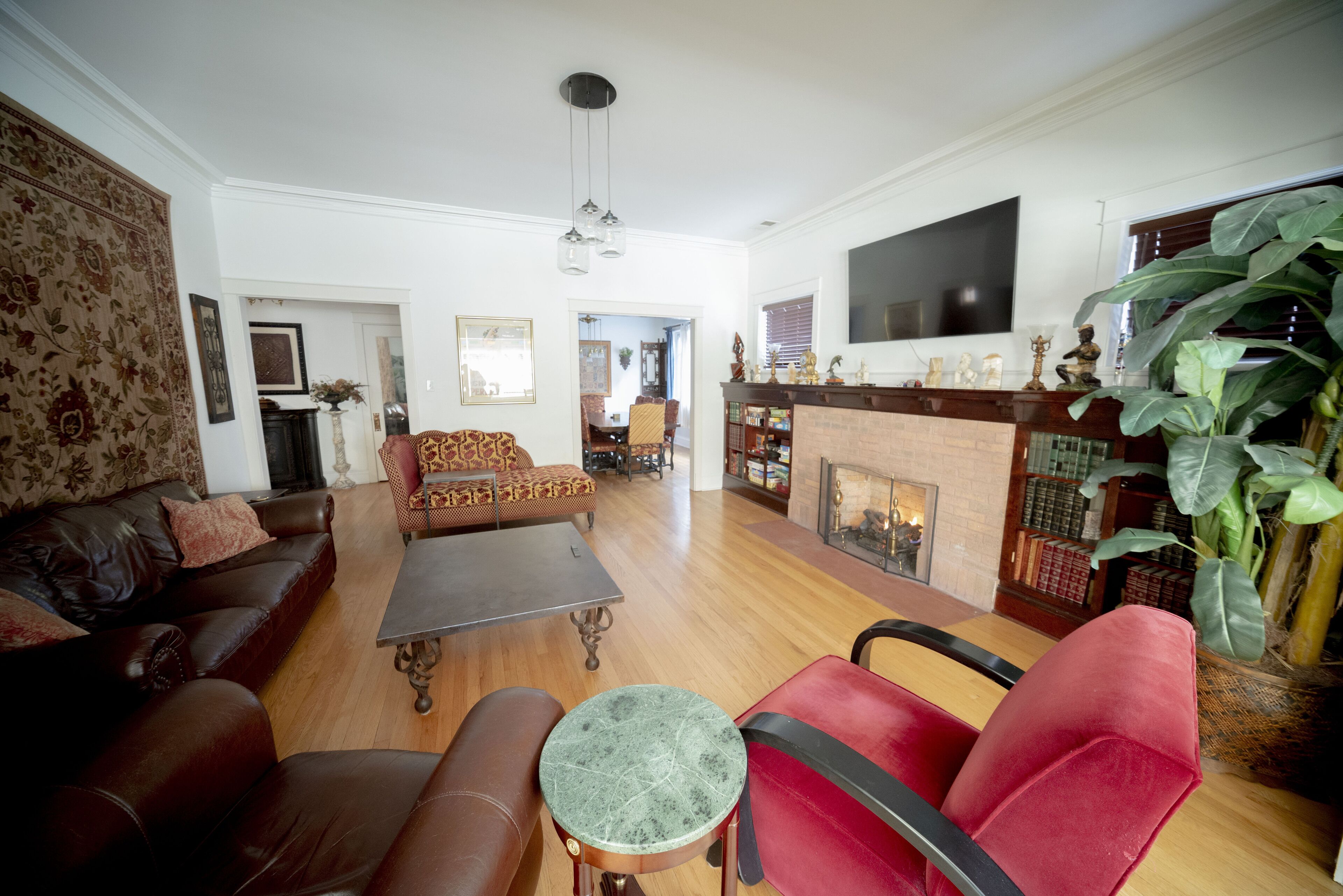 Una sala de estar con chimenea, sofás de cuero, una mesa de centro y un televisor montado en la pared.