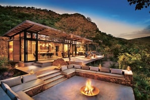 A modern outdoor living area with a fire pit, seating, and a covered patio. - Black Bear Lodge (Ocoee)