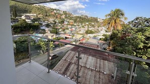 A balcony with a view of a residential area, including houses and greenery. - Gulfview Townhouse With Pool and Jacuzzi (Diego Martin)