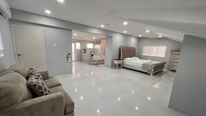 Un dormitorio amplio y luminoso con una cama grande, una mesita de noche y un armario.