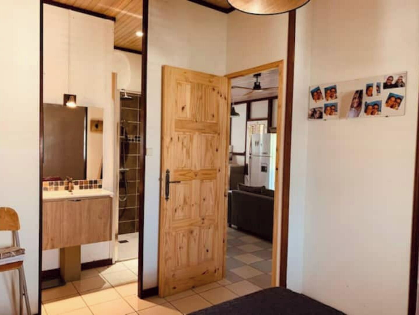 Una cocina moderna con armarios de madera, salpicadero de azulejos y una puerta de madera grande que da a un comedor.