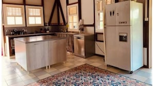 Una cocina con una isla central, un refrigerador y un lavabo.